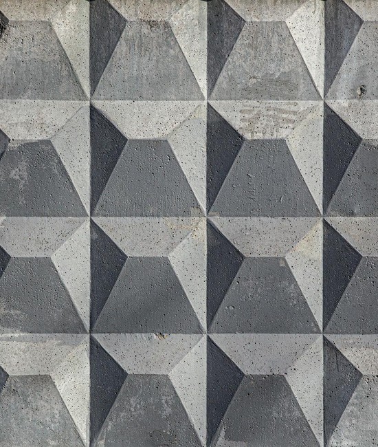 Close-up of a textured geometric concrete wall with a pattern.